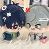 A plush keychain set featuring two anime-style characters, one with dark blue hair and another with silver hair, resting on w