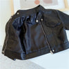 A black faux leather zip-up jacket laid flat on a white surface.