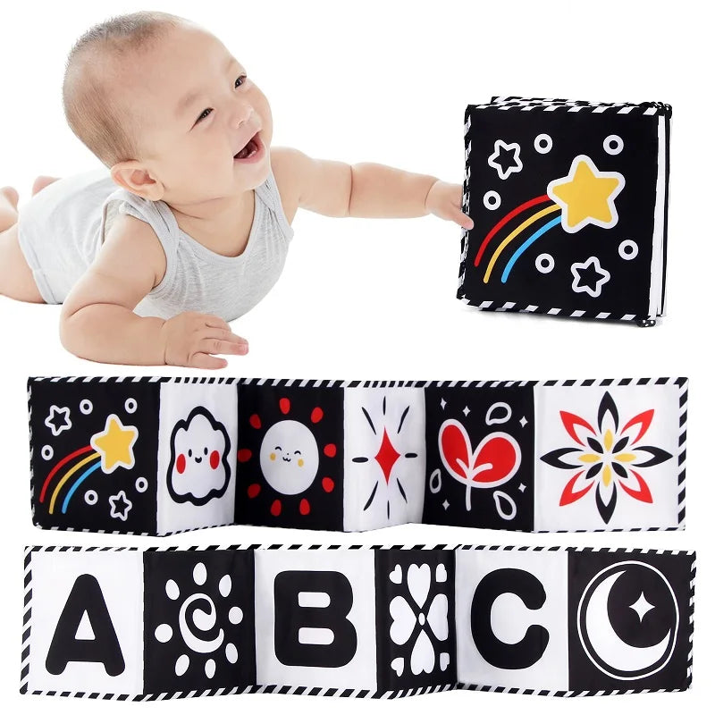 A baby is shown next to a black and white sensory cloth book featuring stars, rainbows, and letters A through C.