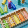 A colorful board game featuring plastic bottles of various colors and shapes for a guessing game.