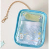 A light blue storage pouch with a clear plastic window and a gold chain keychain, containing soft fabric items for dolls.