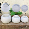 A set of three white silicone round pot molds for DIY planters and candles displayed on a wooden surface.
