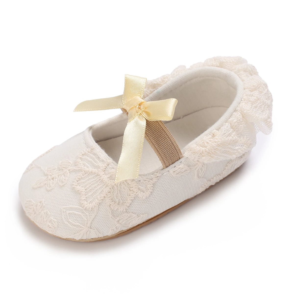 A pair of light beige lace-trimmed baby girl moccasin shoes with a satin bow.