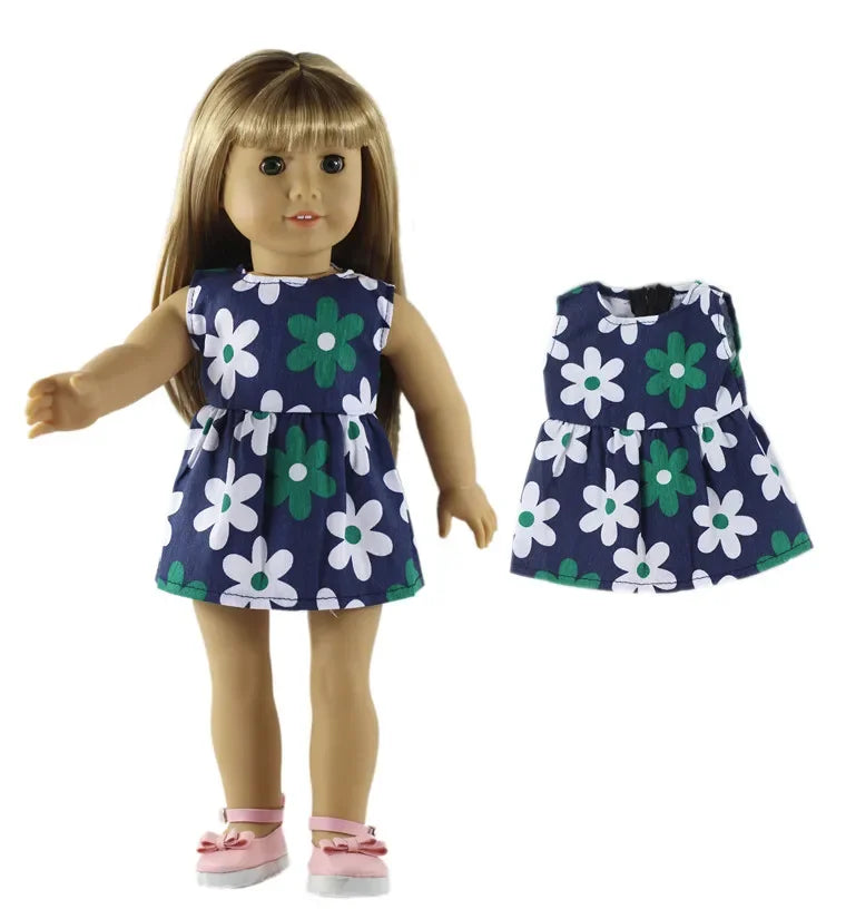 A doll wearing a navy blue dress with a green and white floral pattern.