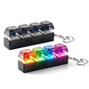 A black illuminated stress-relief keychain toy featuring multiple colored keyboard buttons.