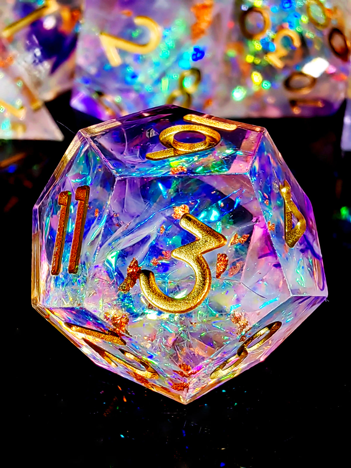 A handcrafted resin polyhedral die with a purple hue and gold numbers, resting on a dark surface.