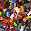 A bulk set of colorful building blocks in various colors and shapes scattered on a surface.