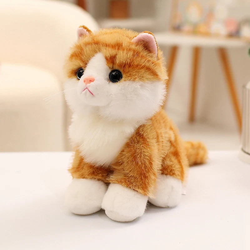 An adorable sitting kitten plush doll with orange and white fur, looking to the side.
