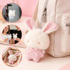 A white plush bunny keychain with pink checkered ears is displayed next to a light pink bag.
