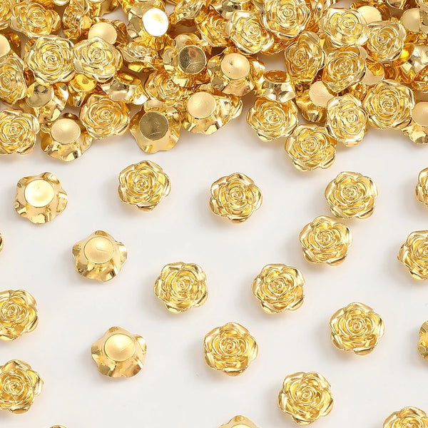A pile of 12mm gold rose flower resin flat back beads for jewelry making.