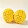 Two bright yellow mango squishy stress relief balls with a crispy texture