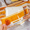 A package of Slow-Rise Toast Squishy Stress Relief Toy with an orange label and white squishy item.