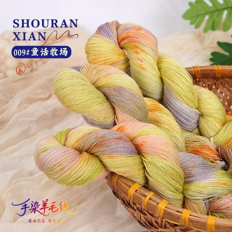 A bundle of hand-dyed Australian wool yarn showing a gradient of yellow, orange, and gray colors in a woven basket.