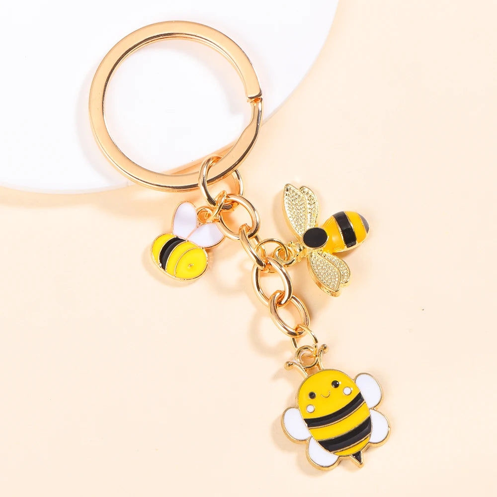 Gold-toned enamel flower keychain featuring a bee and daisy design.