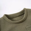 A close-up of a olive green knitted baby outfit set featuring a bear print tee and shorts.