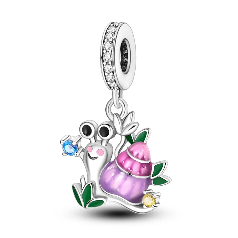 A silver heart charm bead featuring a pink zircon gemstone and a small green leaf detail.