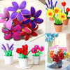 A collection of colorful chenille stem craft sticks in various flower shapes and colors displayed in potted plants.