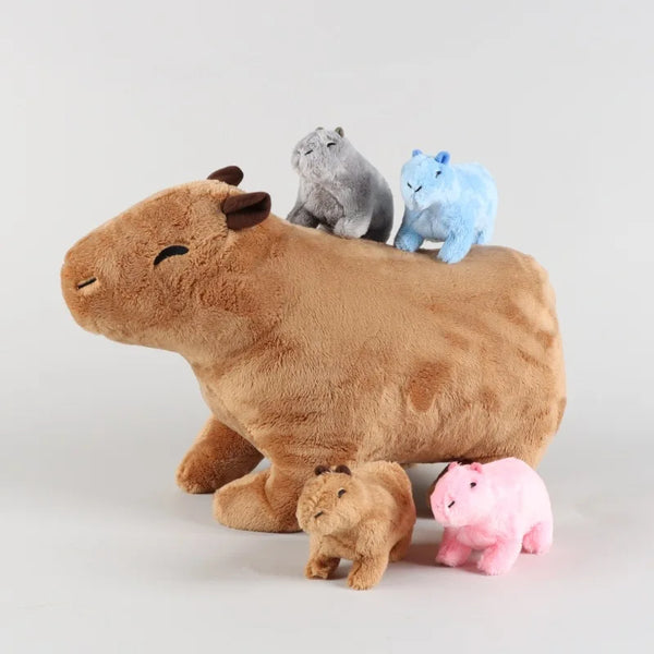A brown capybara plush toy with three small gray, blue, and pink animal figures sitting on its back.