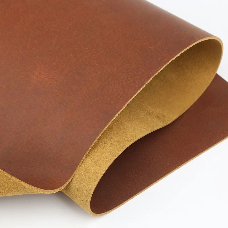 A roll of rust red crazy horse leather hide with an oily finish, shown in a curved shape.
