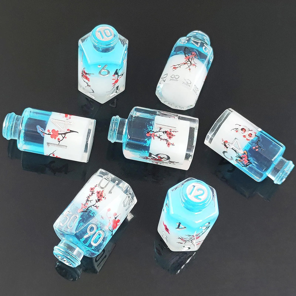 A set of seven floral resin potion bottles shaped like polyhedral dice, featuring various numbers and designs.