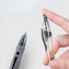A hand holds a silver retractable gel pen, showing the tip and barrel of the writing instrument.