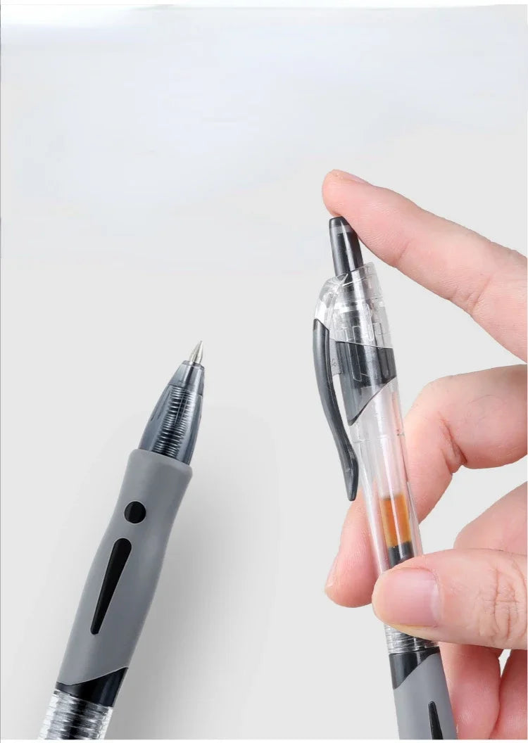 A hand holds a silver retractable gel pen, showing the tip and barrel of the writing instrument.