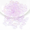 A pile of translucent purple butterfly glass beads for jewelry making.