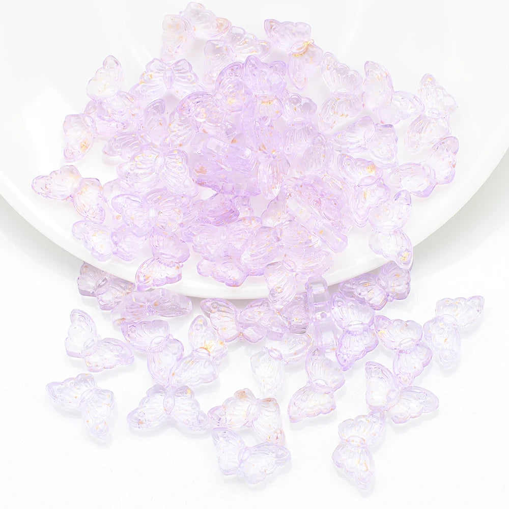 A pile of translucent purple butterfly glass beads for jewelry making.