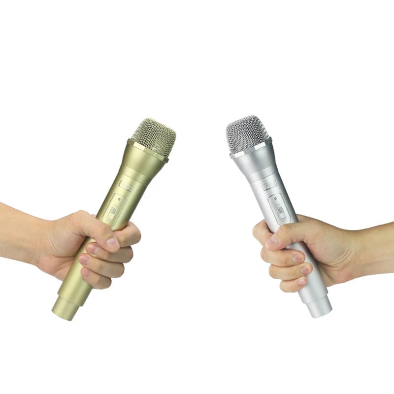 A hand holds a realistic toy microphone prop for kids' performances.