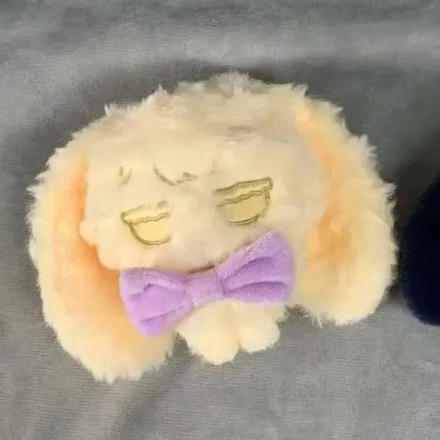 A fluffy yellow plush keychain featuring a face and a purple bow.