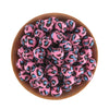 A pile of pink and blue leopard print silicone beads in a wooden bowl for jewelry making