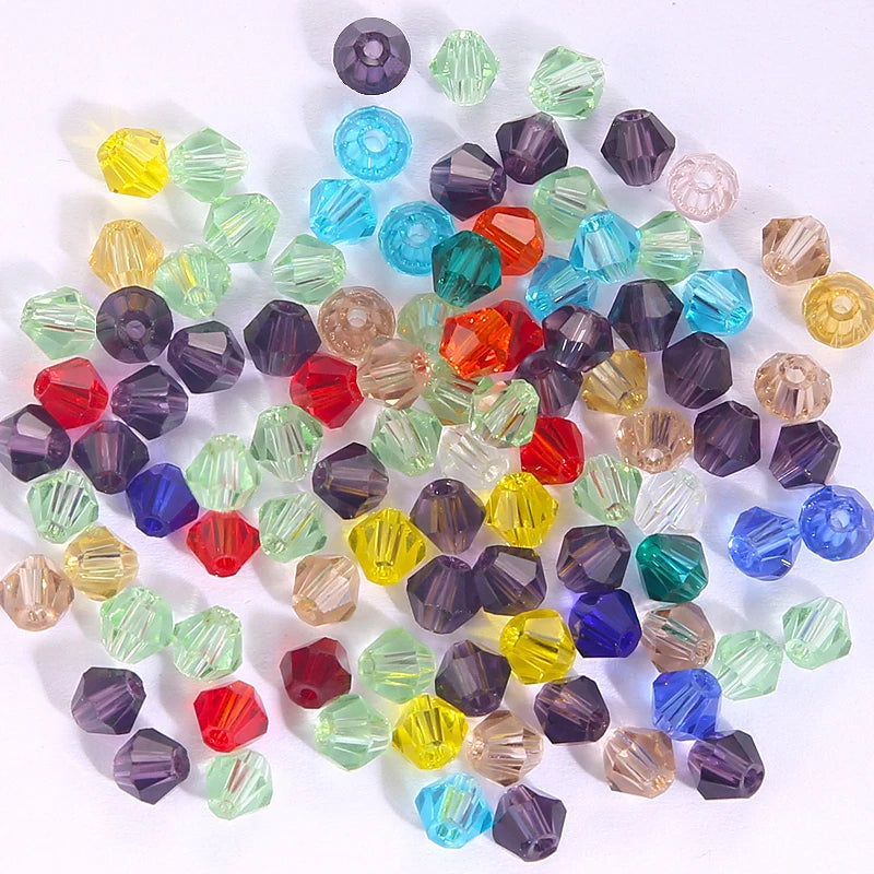 A collection of faceted crystal bicone glass beads in various shades of green, purple, blue, and amber.