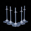 A set of transparent doll display stands with waist clips shown against a black background.