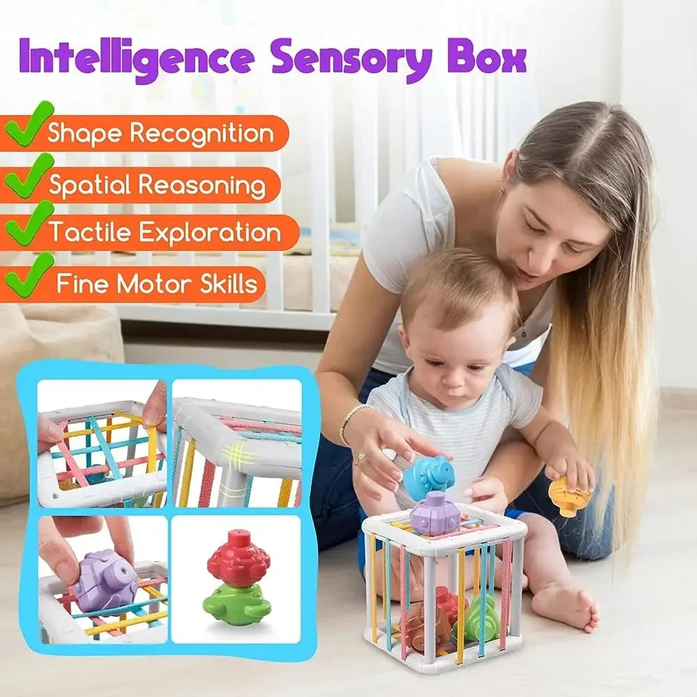 A woman is playing with a colorful Montessori shape sorter cube for a baby, demonstrating fine motor skills and spatial reaso
