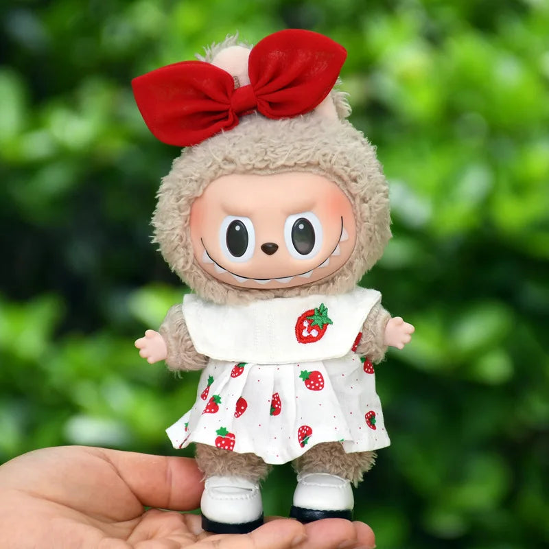 A cute plush doll dressed in a strawberry party outfit with a red bow and white dress
