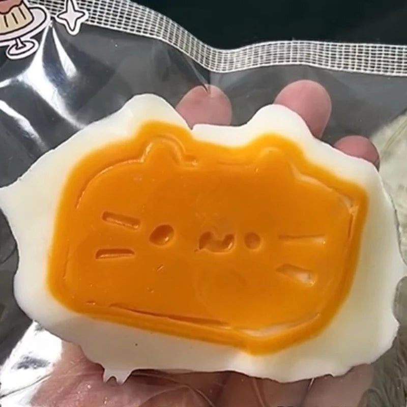 A squishy stress-relief toy shaped like a cat, made of soft, orange and white material.