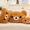 Three soft brown Rilakkuma plush hand rest pillows resting on a white surface.
