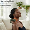 A woman is using a black shiatsu massager on her neck in a bright indoor setting.
