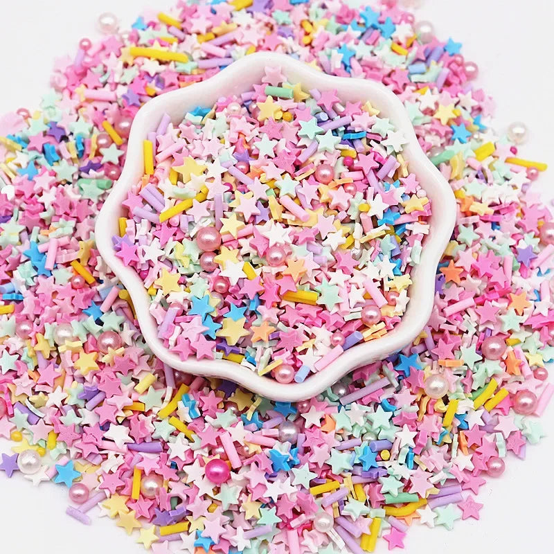 A pile of pink and multicolored polymer clay sprinkles scattered on a white background.