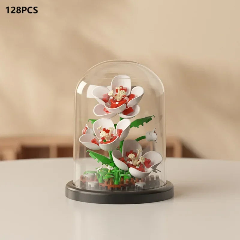 A clear glass display shows a miniature floral bouquet made of building blocks with red and white petals.