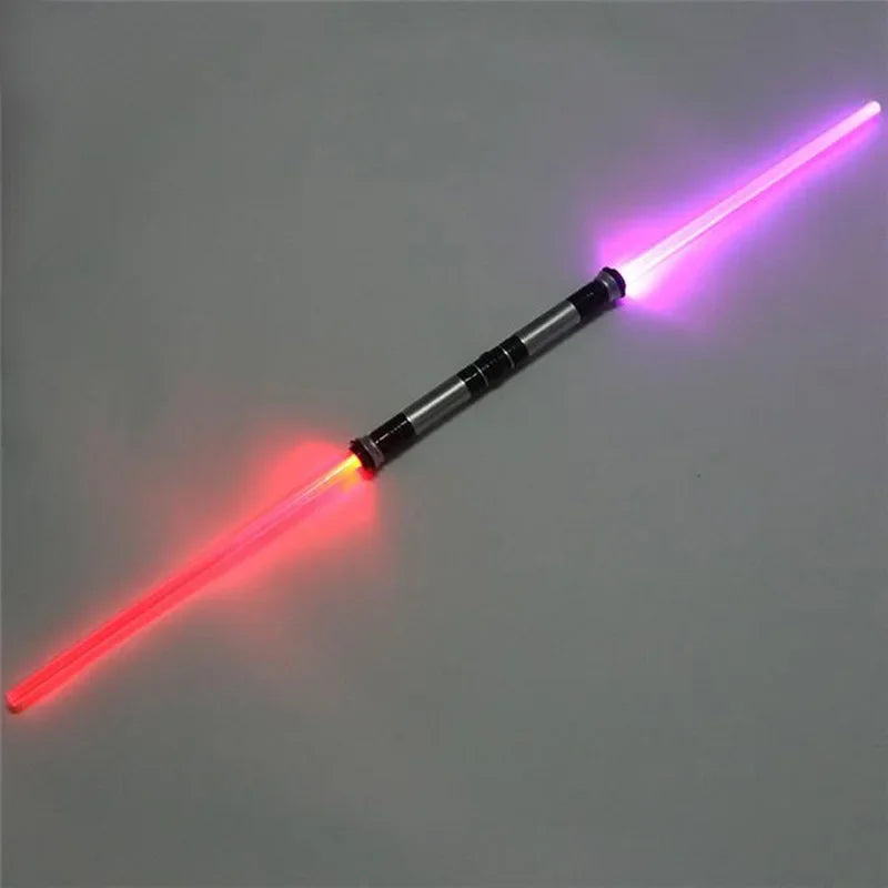 A toy lightsaber with a glowing red blade and a purple blade, illuminated against a gray background.