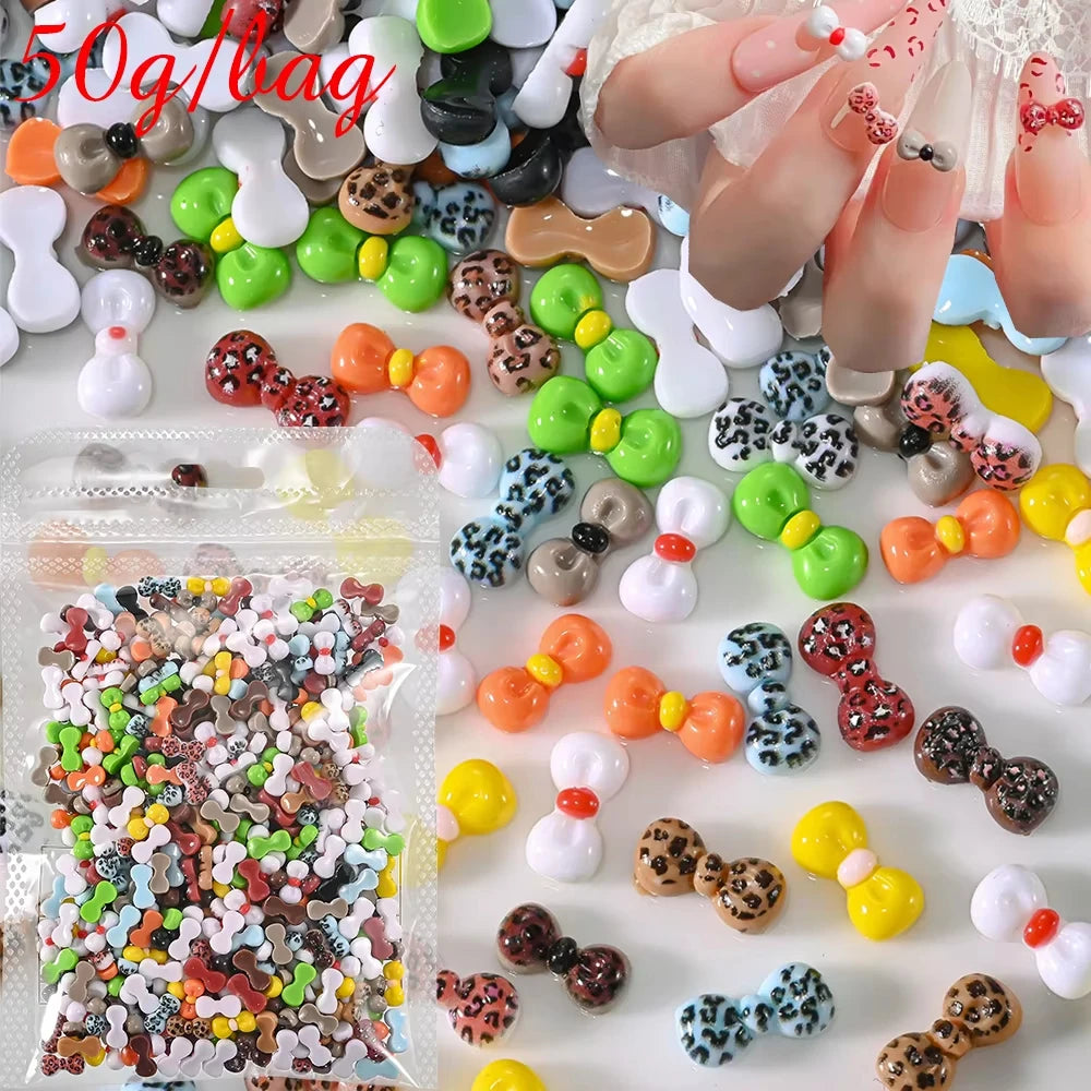 A close-up of various multicolor resin nail charms, including beads and shapes, arranged on a white surface.