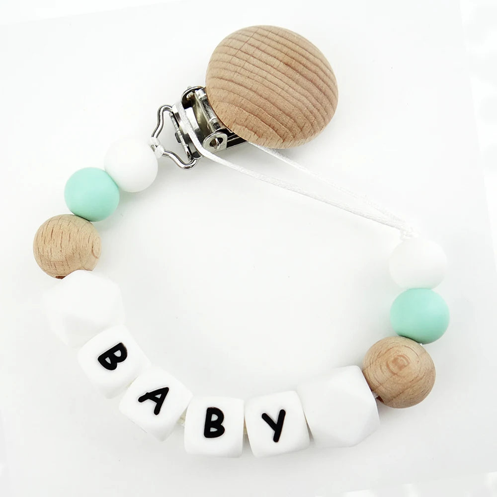 A personalized name pacifier clip featuring wooden and silicone teething beads on a white background.
