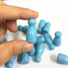 A hand holds a set of ten light blue wooden chess pawns for board games.