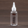 Bouteille en verre transparent d'huile d'amortisseur silicone Falcon 1000 avec un embout doseur blanc.