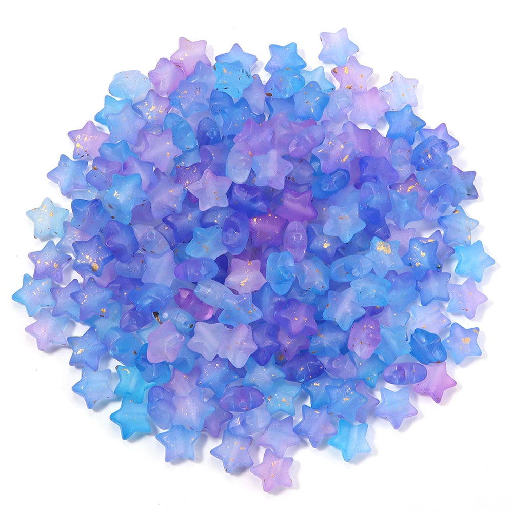 A pile of colorful transparent star acrylic beads in shades of blue and purple for jewelry making