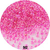 A close-up view of numerous colorful round glass seed beads in various shades of pink and magenta.