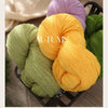 A bundle of bright yellow yarn is shown on a dark basket, highlighting its soft texture for knitting projects.