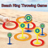 A set of five colored rings and stakes for a beach ring throwing game on sand.