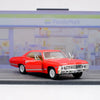 A red 1967 Chevrolet Impala diecast model car in pull-back action on a gray surface.